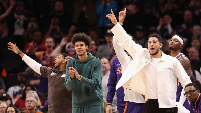 Phoenix Suns' Devin Booker, Cameron Johnson and Cameron Payne react on the bench during a game at Footprint Center in Phoenix, Arizona.