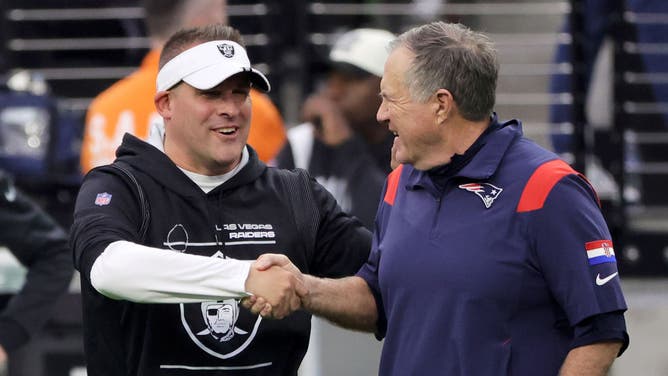 Head coach Josh McDaniels of the Las Vegas Raiders and head coach Bill Belichick of the New England Patriots shake hands as they talk before their game.