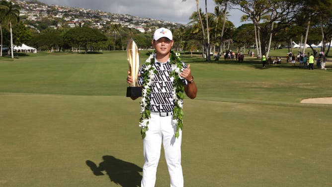 Si Woo Kim poses with the trophy after winning the 2023 Sony Open at Waialae Country Club in Honolulu, Hawaii.