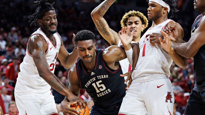 Texas A&M Aggies big Henry Coleman III fights for a rebound against Arkansas Razorbacks' Ricky Council IV and Makhel Mitchell at Bud Walton Arena in Fayetteville, Arkansas.
