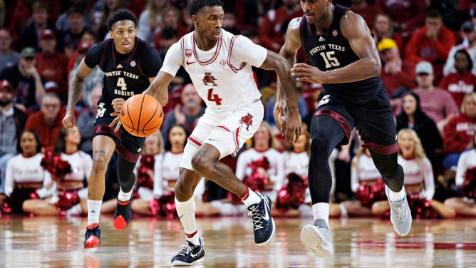 Arkansas' Davonte Davis dribbles down the court against Texas A&M's Henry Coleman III at Bud Walton Arena in Fayetteville, Arkansas.