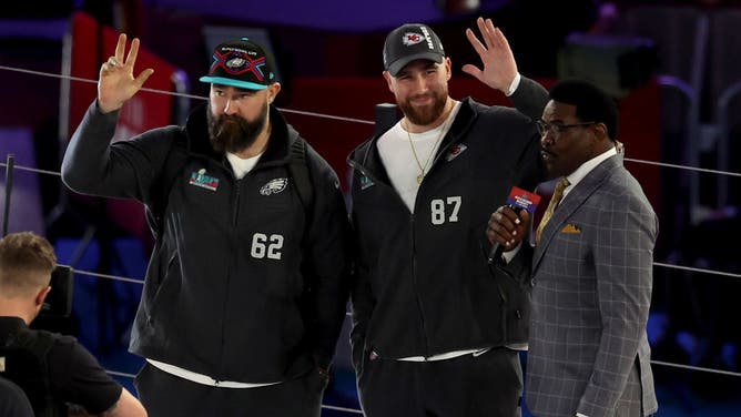 Brothers Jason Kelce of the Philadelphia Eagles and Travis Kelce of the Kansas City Chiefs wave onstage during Super Bowl LVII Opening Night.