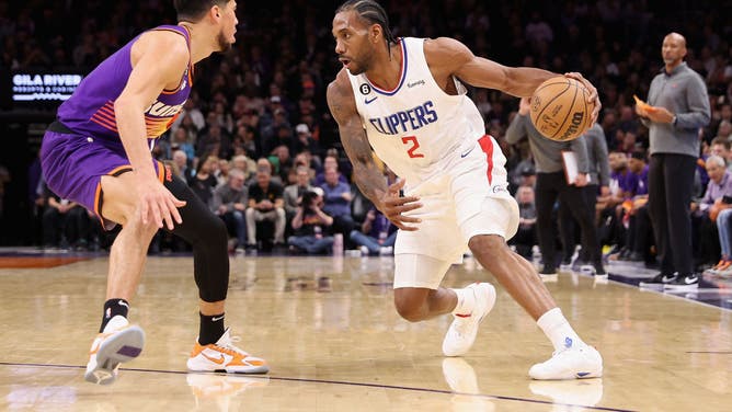 Clippers' Kawhi Leonard dribbles past Suns' Devin Booker at the Footprint Center in Phoenix, Arizona.