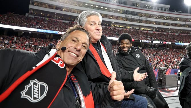 ESPN NHL sportscasters Chris Chelios, Steve Levy and P.K. Subban look on during the first intermission during the 2023 Navy Federal Credit Union NHL Stadium Series game between the Washington Capitals and the Carolina Hurricanes.