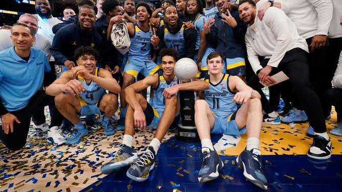 The Marquette Golden Eagles celebrate with the Big East regular season championship trophy after defeating the St. John's Red Storm at Fiserv Forum in Milwaukee, Wisconsin.