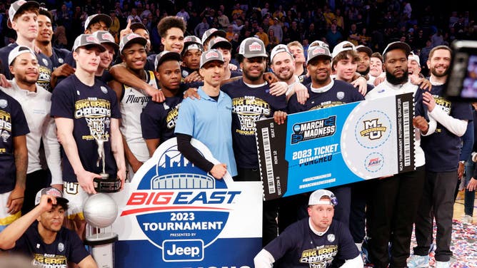 The Marquette Golden Eagles pose with the trophy after defeating the Xavier Musketeers in the Big East Basketball Tournament Championship at Madison Square Garden.