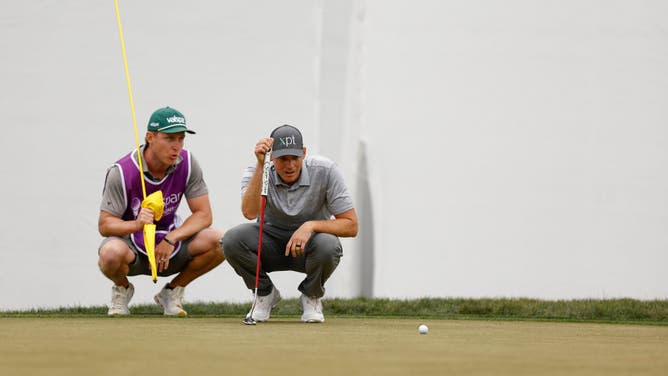 Adam Schenk of the United States and caddie David Cooke line up a putt during the Valspar Championship at Innisbrook Resort and Golf Club.