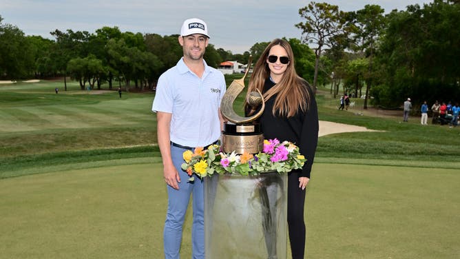 Taylor Moore celebrates with the trophy and fiance Lexi Sorensen after winning the Valspar Championship 2023 at Innisbrook Resort and Golf Club in Palm Harbor, Florida.