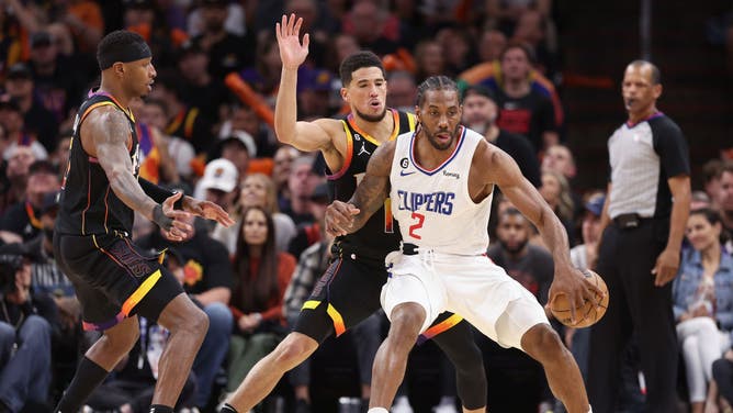 Los Angeles Clippers wing Kawhi Leonard posts up Suns SG Devin Booker during Game 2 of the 2023 Western Conference 1st-Round Playoffs at Footprint Center in Phoenix, Arizona.