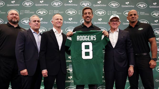 New York Jets general manager Joe Douglas, team president Hymie Elhai, team owner Christopher Johnson, quarterback Aaron Rodgers, team owner Woody Johnson, and head coach Robert Saleh pose during an introductory press conference.