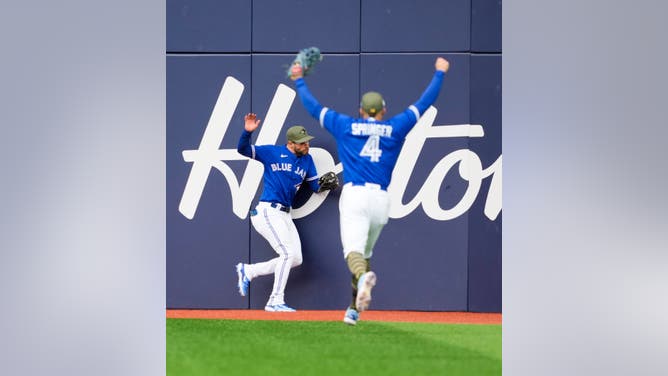 Kevin Kiermaier #39 of the Toronto Blue Jays makes a jumping catch against the Baltimore Orioles as teammate George Springer #4 celebrates during the sixth inning in their MLB game at the Rogers Centre on May 20, 2023 in Toronto, Ontario, Canada.