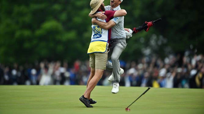 Nick Taylor of Canada celebrates with his caddie after making an eagle putt on the 4th playoff hole to win the RBC Canadian Open at Oakdale Golf & Country Club.