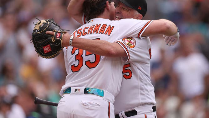 Adley Rutschman #35 of the Baltimore Orioles hugs his father Randy after batting during the T-Mobile Home Run Derby at T-Mobile Park, broadcast on ESPN.