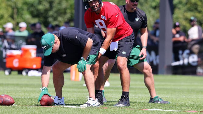Aaron Rodgers takes a snap as New York Jets offensive coordinator Nathaniel Hackett looks on during training camp at Atlantic Health Jets Training Center.