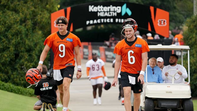 Quarterbacks Joe Burrow and Jake Browning of the Cincinnati Bengals walk to the field during training camp.