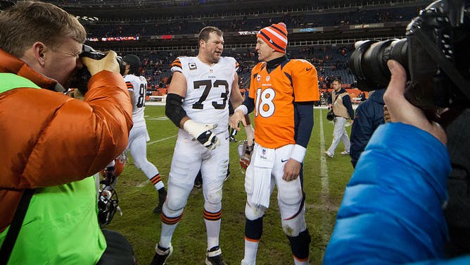 Quarterback Peyton Manning of the Denver Broncos has a word with tackle Joe Thomas of the Cleveland Browns after a game at Sports Authority Field at Mile High.
