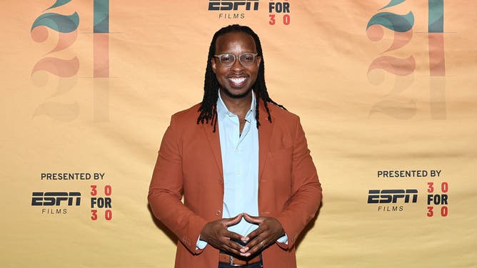 Ibram X. Kendi stands in front of a background featuring ESPN Films 30 For 30 series.