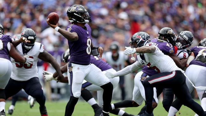 Ravens QB Lamar Jackson throws a pass while being pressured by Houston Texans safety Jalen Pitre in NFL Week 1 at M&T Bank Stadium in Baltimore, Maryland.