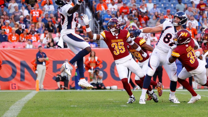 Brandon Johnson of the Denver Broncos catches a Hail Mary over Percy Butler of the Washington Commanders as time expires during the fourth quarter at Empower Field At Mile High on September 17, 2023 in Denver, Colorado.