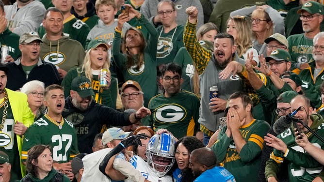 Amon-Ra St. Brown of the Detroit Lions celebrates with fans after scoring a touchdown against the Green Bay Packers.