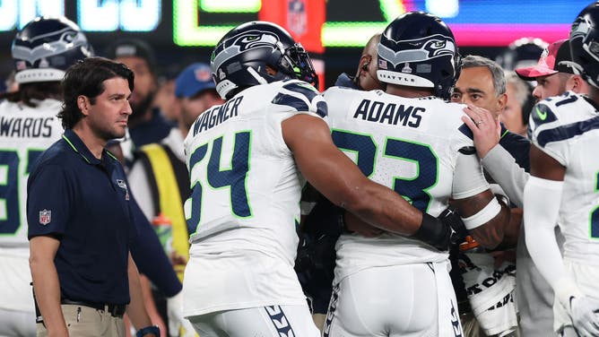 Trainers and teammate help Jamal Adams of the Seattle Seahawks off the field after he took a hit in the head attempting to tackle Daniel Jones of the New York Giants.