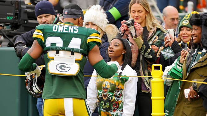 Simone Biles talks with her husband Jonathan Owens of the Green Bay Packers prior to a game.