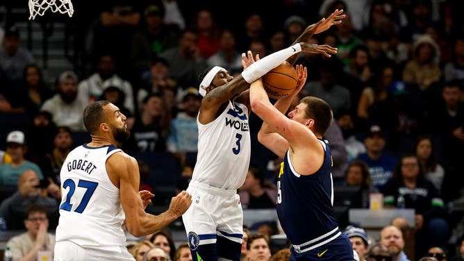 Timberwolves SF Jaden McDaniels blocks a shot by Denver Nuggets C Nikola Jokic in an NBA game at Target Center in Minneapolis.