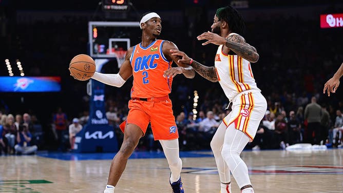 Thunder PG Shai Gilgeous-Alexander looks to pass with Atlanta Hawks wing Saddiq Bey guarding him at Paycom Center in Oklahoma City.