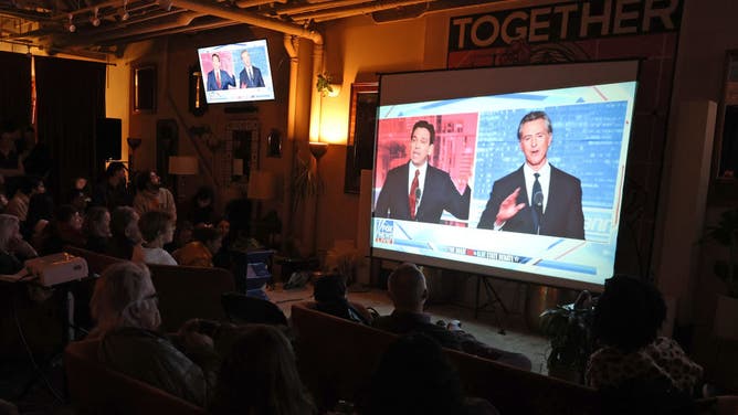 People watch a debate between California Gov. Gavin Newsom and Florida Gov. Ron DeSantis during a watch party.