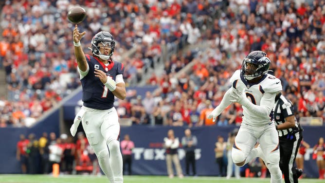 Texans QB C.J. Stroud throws a pass on the run while being chased by a Denver Broncos defensive linemen in NFL Week 13 at NRG Stadium in Houston.