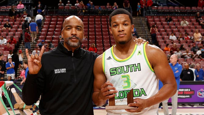 Head coach Amir Abdur-Rahim poses with Chris Youngblood of the South Florida Bulls after he was awarded the MVP trophy for his play against the Florida State Seminoles during the AutoNation Orange Bowl Basketball Classic.
