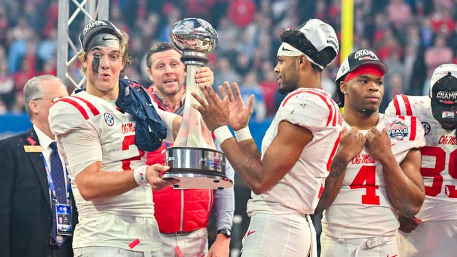 Ole Miss QB Jaxson Dart and WR Tre Harris hold the Peach Bowl trophy after beating the Penn State Nittany Lions at Mercedes-Benz Stadium in Atlanta, Georgia.