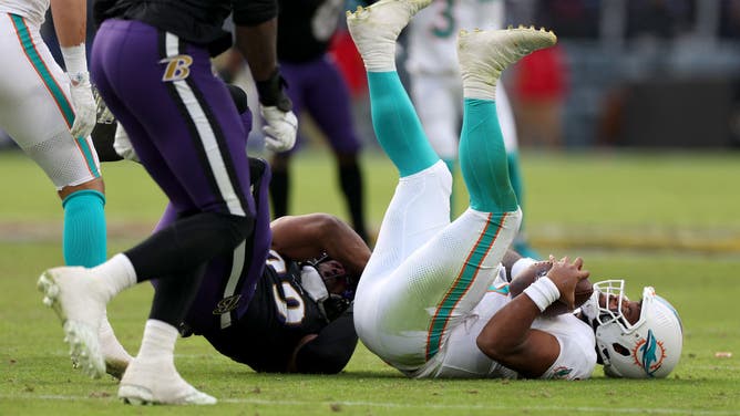 Linebacker Odafe Oweh of the Baltimore Ravens sacks quarterback Tua Tagovailoa of the Miami Dolphins during a Week 17 matchup.