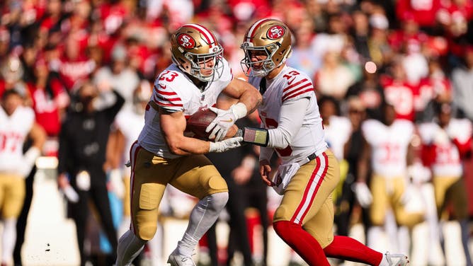 San Francisco 49ers QB Brock Purdy hands the ball off to RB Christian McCaffrey in NFL Week 17 game vs. the Washington Commanders at FedExField in Landover, Maryland.