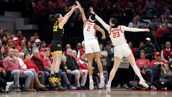 Caitlin Clark of the Iowa Hawkeyes makes a three-point shot over the defense of Taylor Thierry of the Ohio State Buckeyes and Rebeka Mikulasikova during the first quarter of the game at Value City Arena on January 21, 2024 in Columbus, Ohio.