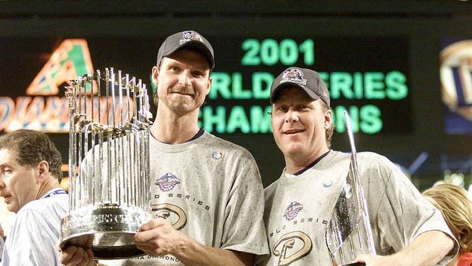 Co-World Series MVP winners Diamondbacks' Randy Johnson and Curt Schilling hold the trophys after winning the World Series over the Yankees at Bank One Ballpark.