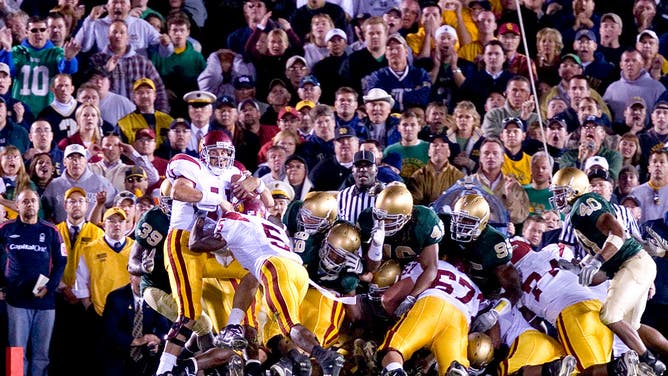 Trojans QB Matt Leinart is pushed in to the end zone by teammate Reggie Bush for a game-winning TD vs. the Fighting Irish at Notre Dame Stadium in South Bend, Indiana.