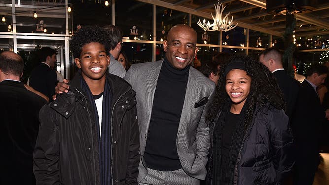 Deion Sanders stands between son Shedeur and daughter Shelomi. Sanders believes intact families are important for the development of young people.