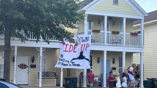 Alabama fans having a little fun with Texas fans with signs outside their house