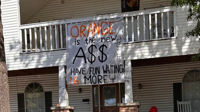 Alabama fans get creative with their 'signs' for Tennessee fans, near the stadium.