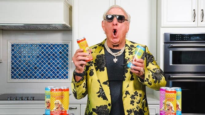 Ric Flair poses with energy drinks