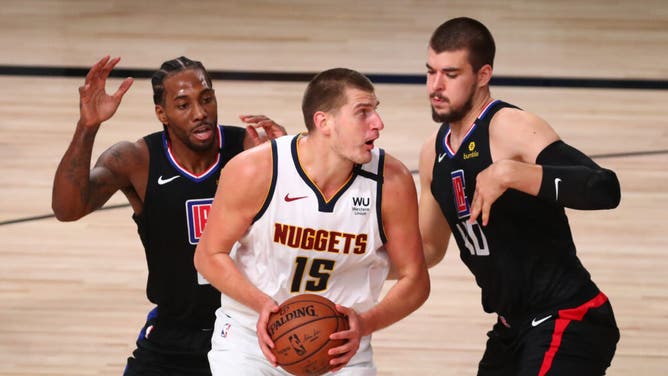 Los Angeles Clippers wing Kawhi Leonard and C Ivica Zubac pressure Denver Nuggets C Nikola Jokic in the 2020 NBA Playoffs at AdventHealth Arena in Orlando, Florida.