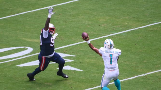 Dolphins QB Tua Tagovailoa throws the ball as Patriots DT Christian Barmore approaches at Hard Rock Stadium in Miami.