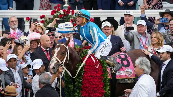Jockey Javier Castellano aboard Mage tosses a rose to people in the Winner's Circle after winning the 149th Kentucky Derby Saturday at Churchill Downs in Louisville, Kentucky.