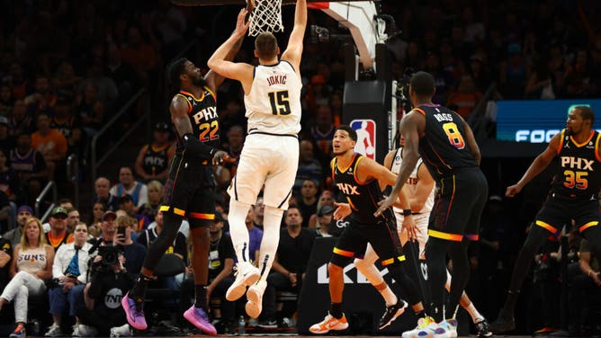 Nuggets C Nikola Jokic drives to the basket against Suns C Deandre Ayton during Game 4 of the 2023 NBA playoffs at Footprint Center in Phoenix.