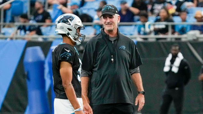 Panthers head coach Frank Reich talks at midfield with QB Bryce Young during Fan Fest at Bank of America Stadium.