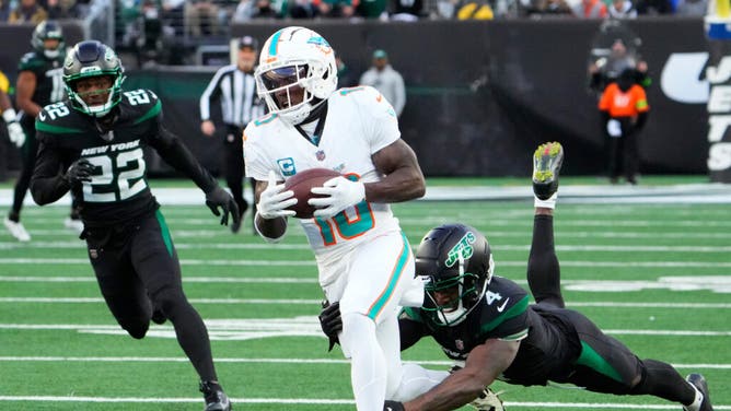 Miami Dolphins WR Tyreek Hill catches a pass for a first down against New York Jets CB D.J. Reed at MetLife Stadium in the 1st-ever NFL Black Friday game.