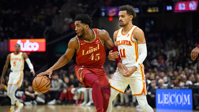 Atlanta Hawks PG Trae Young defends Cavaliers combo guard Donovan Mitchell at Rocket Mortgage FieldHouse in Cleveland, Ohio.