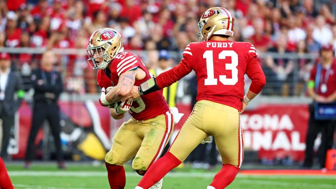 San Francisco 49ers QB Brock Purdy hands the ball off to RB Christian McCaffrey vs. the Cardinals at State Farm Stadium in Glendale, Arizona.