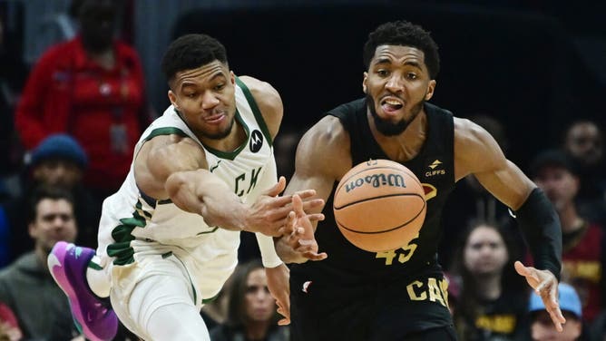 Milwaukee Bucks PF Giannis Antetokounmpo and Cavaliers SG Donovan Mitchell fight for a loose ball at Rocket Mortgage FieldHouse in Cleveland, Ohio.